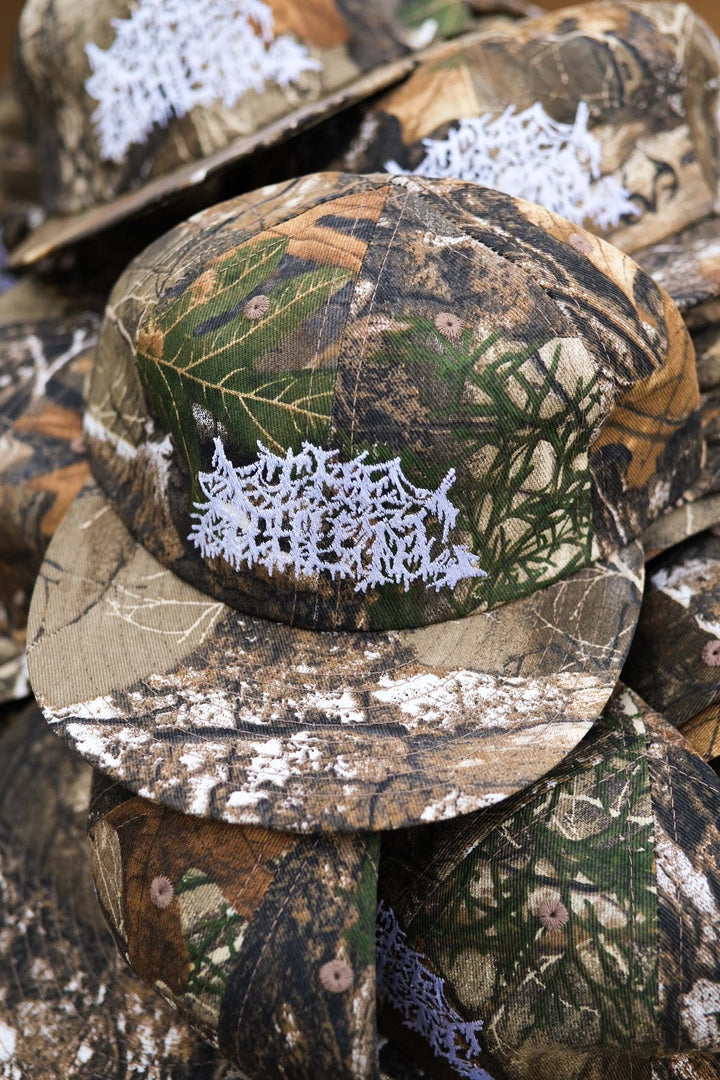The Realtree Realness Cap is a versatile, unstructured 6-panel hat featuring a unique camo pattern that varies slightly with each cap, adding individuality to your gear. Designed in collaboration with Kyle Kelley, it includes a soft, regular-length bill and no top button, ensuring comfort under a helmet. Crafted in the USA, this hat is perfect for everyday wear and is easily packable for on-the-go adventures
