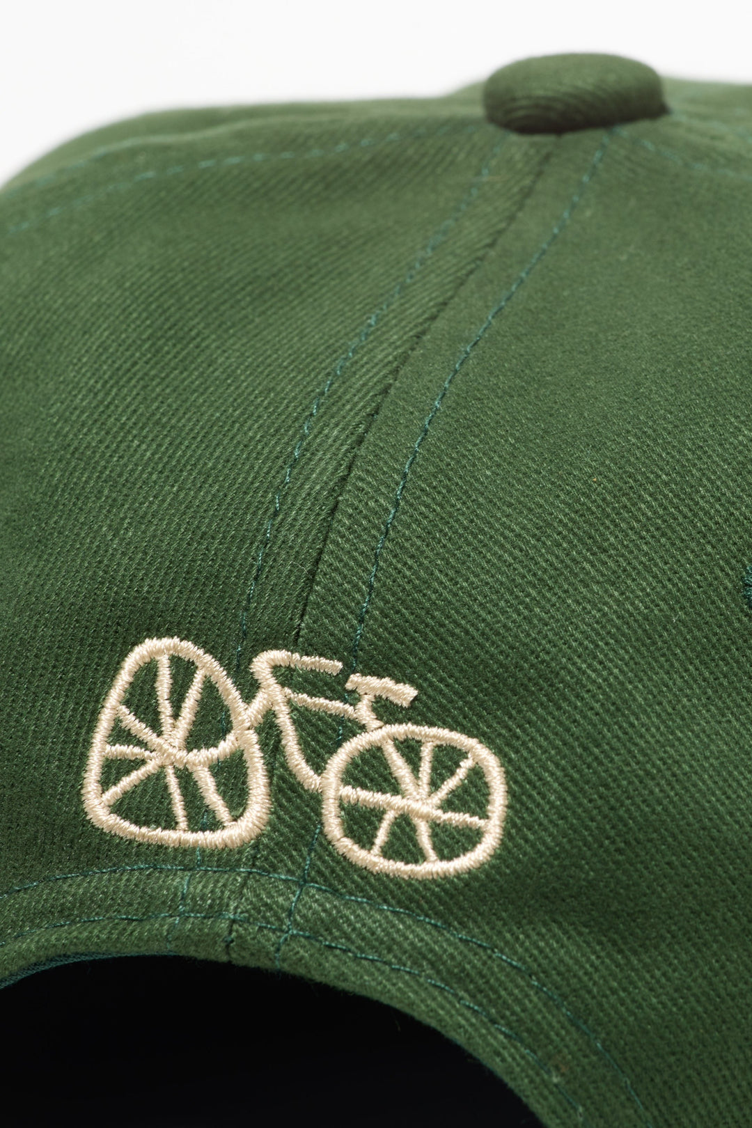 The I LIKE BIKE Hat is a green, 6-panel cap featuring the embroidered phrase "I LIKE BIKE" in white. It includes an adjustable fabric strap with a brass metal clasp for a customizable fit. Made from 100% cotton, this hat offers comfort and style for cycling enthusiasts