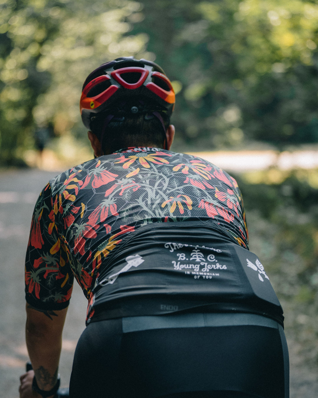 The Men's Flowers Jersey is a cycling jersey designed for both gravel and road cycling. Crafted in California from Italian fabrics by Endo Customs, it features a vibrant floral design by Young Jerks. The jersey is tailored for a snug fit, constructed with lightweight technical Italian fabrics, and includes an embossed rear elastic for added comfort. It also features a full-length reverse YKK zipper for easy ventilation