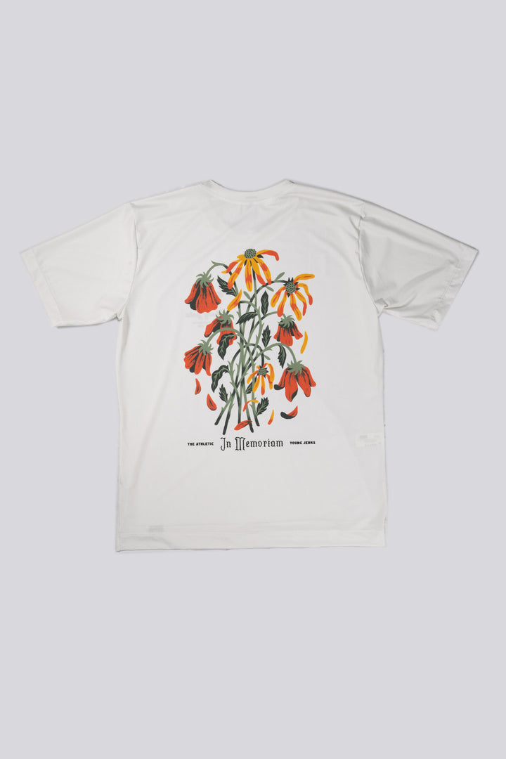 The Men's In Memoriam Short Sleeve Tech Tee is a bright white, short-sleeve shirt featuring a chest decal and a flower design across the back. Ideal for running, cycling, or cross-training, this tee pairs beautifully with black El Sol socks or gold Death Palm designs. Crafted in California from Italian fabrics by Endo Customs, it offers both style and performance for active individuals