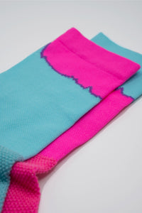 Mismatched socks with teal and pink colors for running or cycling