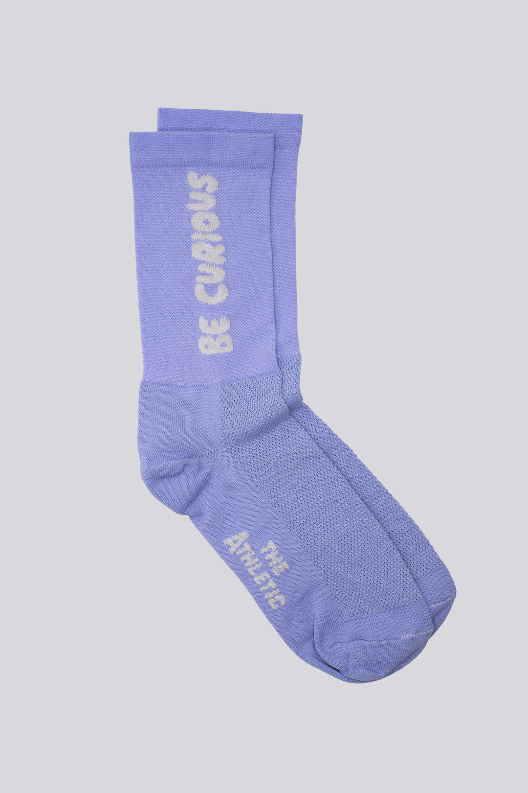 The Be Curious Socks are lavender socks featuring the phrase "Be Curious" on either side, designed for running and cycling. Perfect for cross-training, these socks combine style and performance. Please note that this item is on final sale and is not eligible for returns or exchanges