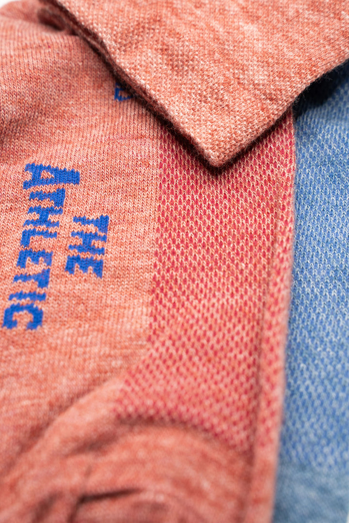 The Elevation Blue and Pink Lightweight Wool Blend Socks are a collaboration between The Athletic Community and Golden Saddle Cyclery. These mismatched socks feature a vibrant blue and pink design, combining lightweight wool and synthetic fibers to keep your feet dry and comfortable during mountain treks or casual outings. Made in the USA with love