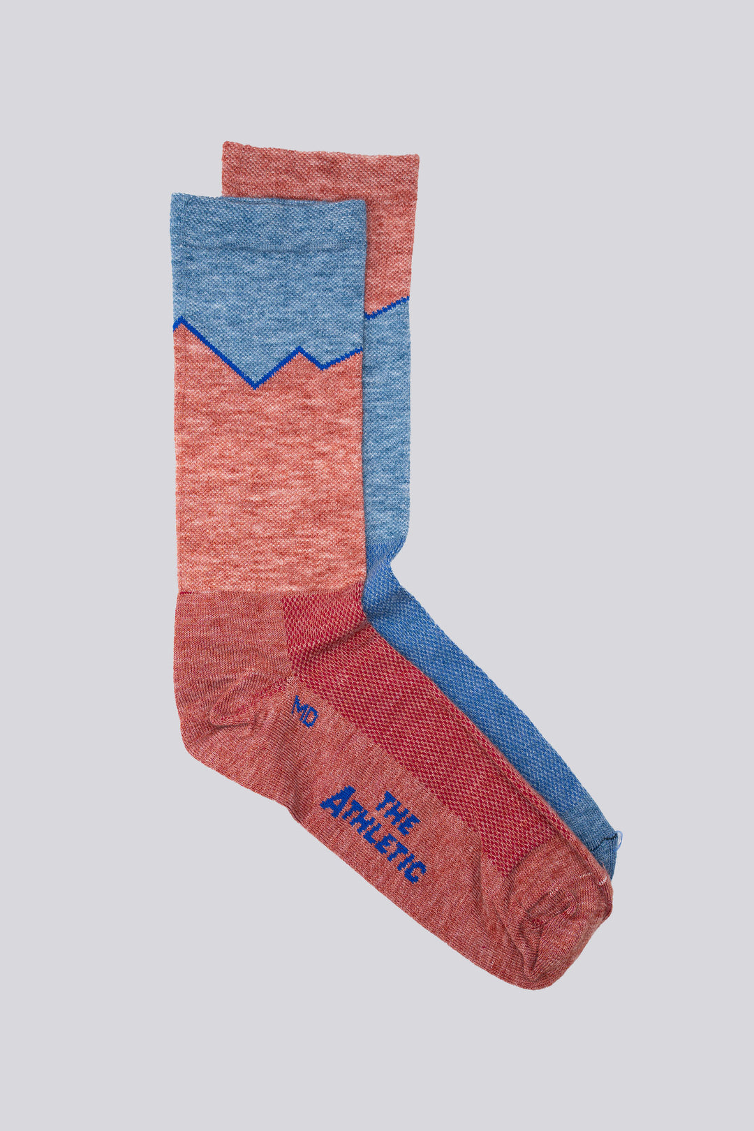 The Elevation Blue and Pink Lightweight Wool Blend Socks are a collaboration between The Athletic Community and Golden Saddle Cyclery. These mismatched socks feature a vibrant blue and pink design, combining lightweight wool and synthetic fibers to keep your feet dry and comfortable during mountain treks or casual outings. Made in the USA with love
