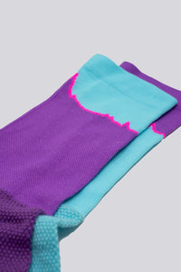 Mismatched socks with teal and purple colors for running or cycling