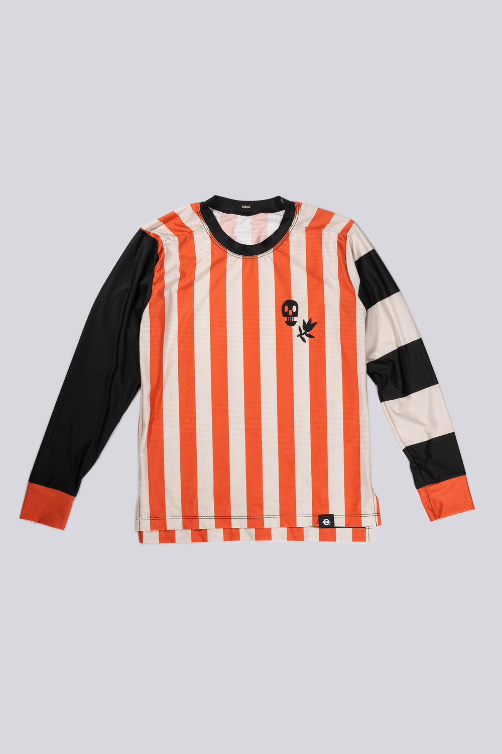 The Women's Harlequin Tech Tee is a long-sleeve, moisture-wicking shirt designed for colder runs or gravel rides. Featuring a bold harlequin stripe pattern, this limited-run tee pairs well with black Death Palm socks and The Athletic cycling bibs. Crafted in California from Italian fabrics by Endo Customs, it offers both style and performance for active individuals