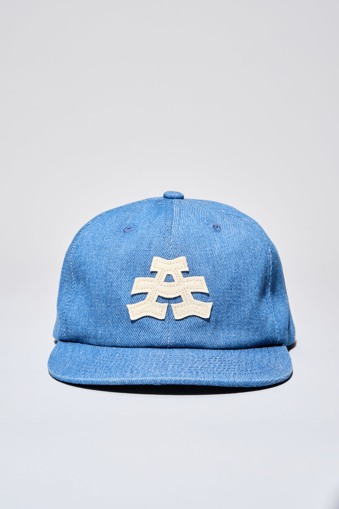 The Athletic Wavy A Denim Hat is a 100% cotton denim cap featuring the embroidered "Wavy A" logo, symbolizing The Athletic's blend of past and future. Designed in collaboration with Young Jerks, this hat offers a timeless, denim aesthetic suitable for various off-bike activities