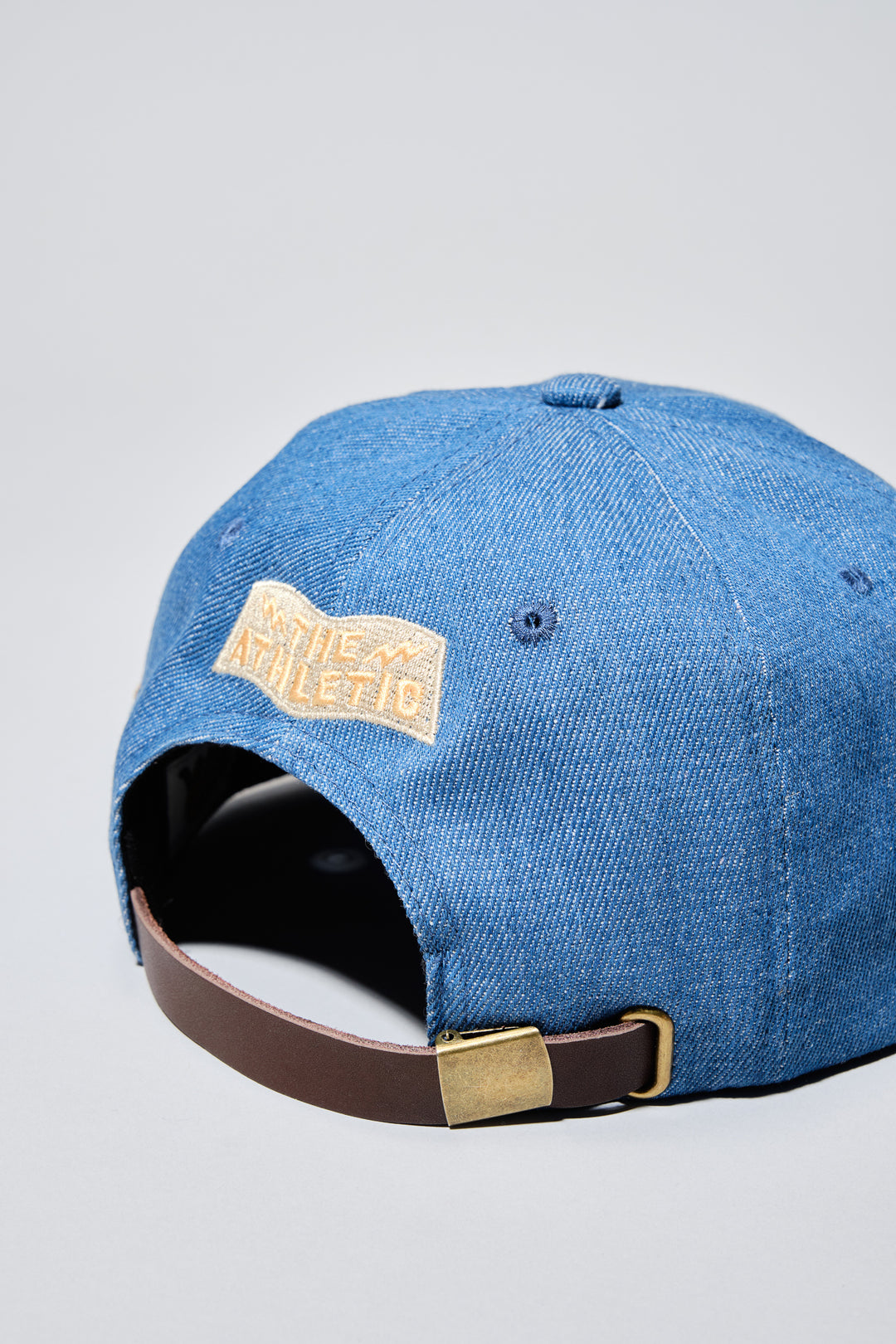 The Athletic Wavy A Denim Hat is a 100% cotton denim cap featuring the embroidered "Wavy A" logo, symbolizing The Athletic's blend of past and future. Designed in collaboration with Young Jerks, this hat offers a timeless, denim aesthetic suitable for various off-bike activities