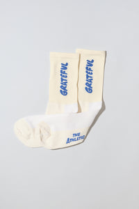 Oatmeal socks with "Grateful" text written in blue.