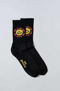 Smiley face socks with "Sure, I like fun" caption. Socks are black.